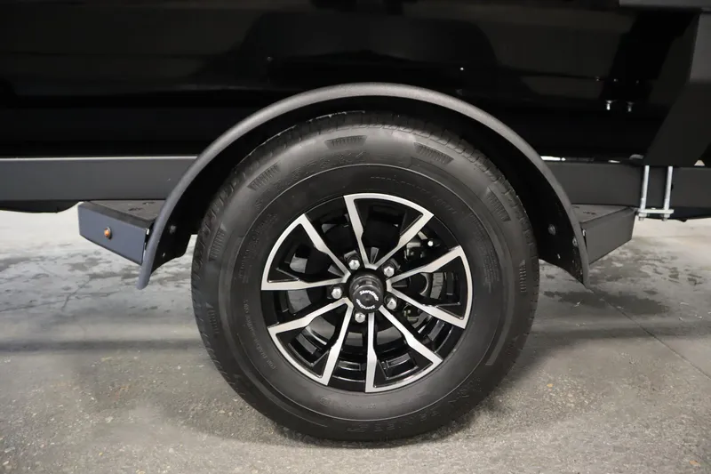 Slide: The Image of 2026 Crestliner 1850 Kodiak WT trailer wheel with black alloy rim and tire. - 46