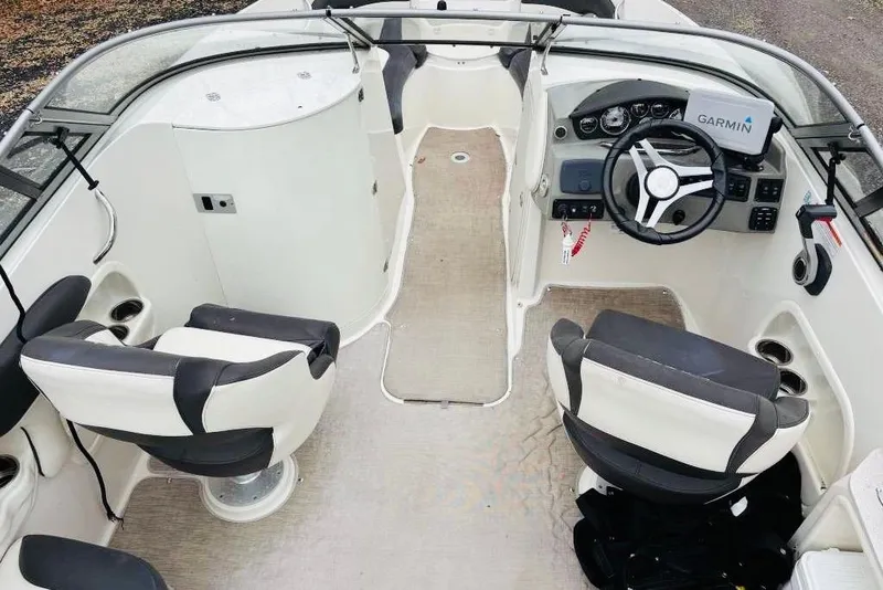Slide: The Image of 2018 Stingray 214 LR boat interior with steering wheel and seating. - 3