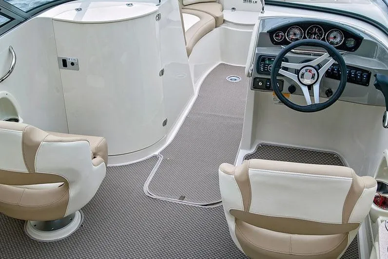 Slide: The Image of Manufacturer Provided Image: 2018 Stingray 214 LR boat interior with beige and white seating, steering wheel, and dashboard. - 9