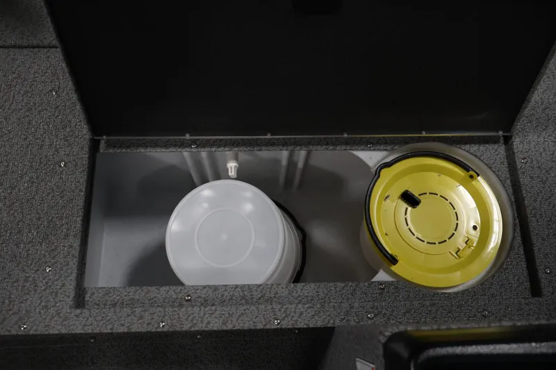 Slide: The Image of Storage compartment in 2026 Crestliner 1850 Kodiak SC boat, featuring a bucket and yellow lid. - 17