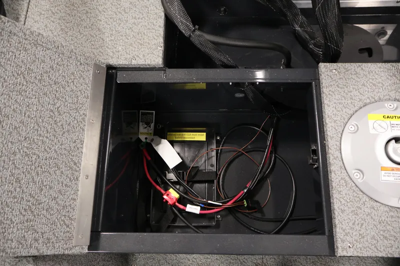 Slide: The Image of Battery compartment of 2026 Crestliner 1850 Kodiak SC boat with wiring and caution labels. - 28