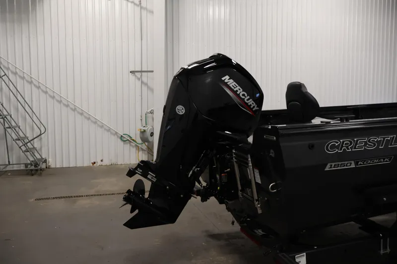 Slide: The Image of 2026 Crestliner 1850 Kodiak SC boat with Mercury outboard motor in a garage. - 30