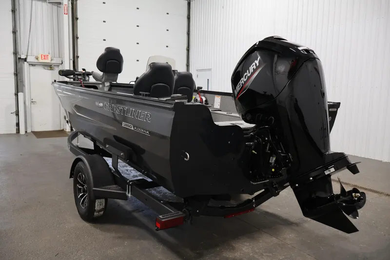 Slide: The Image of 2026 Crestliner 1850 Kodiak SC boat with Mercury outboard motor in a garage. - 6