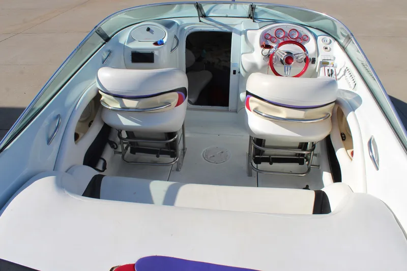Slide: The Image of 1996 Baja 232 boat interior with white seating and red steering wheel. - 10