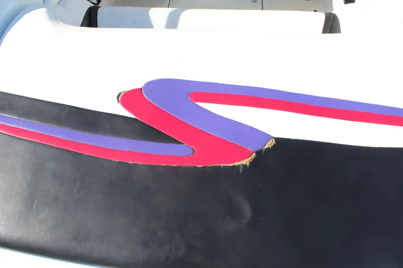 Slide: The Image of 1996 Baja 232 boat seat with colorful design and visible tear. - 11