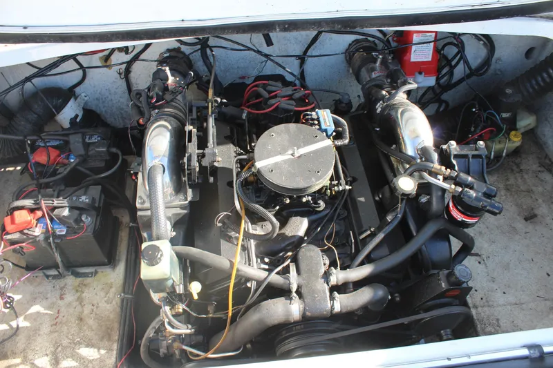 Slide: The Image of Engine compartment of a 1996 Baja 232 boat, showcasing mechanical components and wiring. - 12
