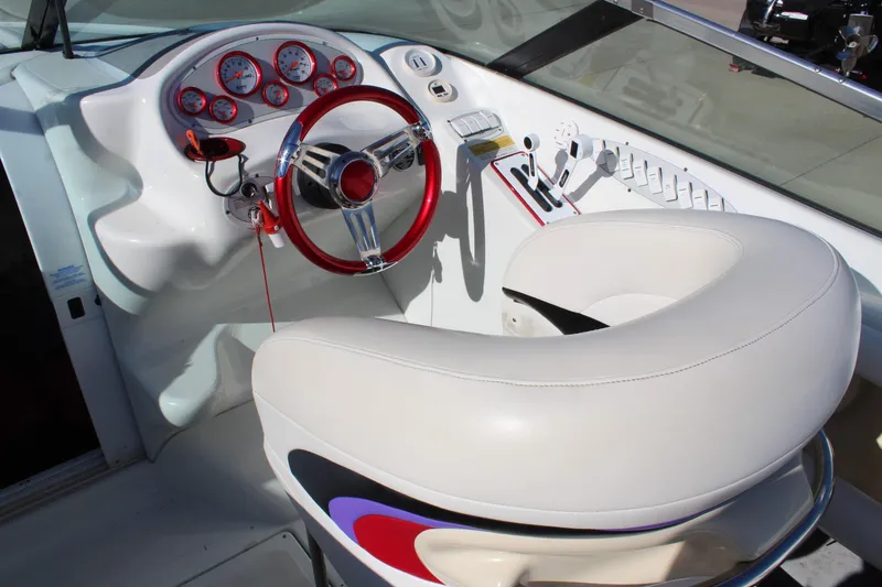 Slide: The Image of Cockpit of a 1996 Baja 232 boat with red steering wheel and white seating. - 16