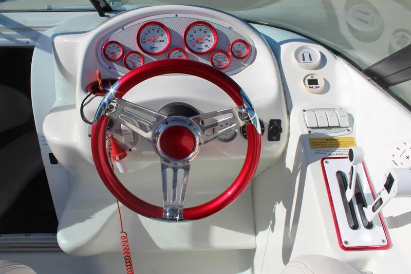 Slide: The Image of 1996 Baja 232 boat dashboard with red steering wheel and gauges. - 17