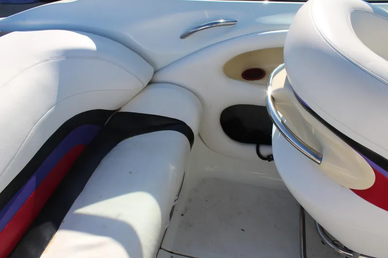 Slide: The Image of Interior of a 1996 Baja 232 boat featuring white and multicolored seating. - 19
