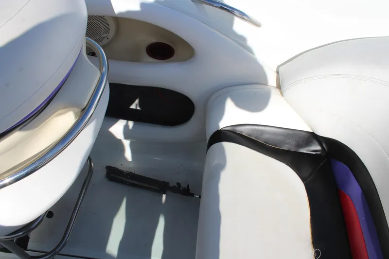 Slide: The Image of Interior of a 1996 Baja 232 boat showing white and black seating. - 20