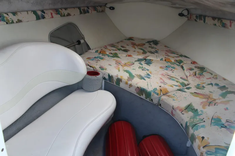 Slide: The Image of Interior of 1996 Baja 232 boat with colorful bedding and white seating. - 28