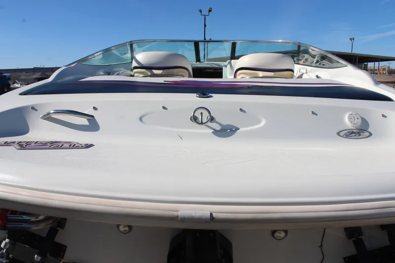 Slide: The Image of 1996 Baja 232 boat rear view, showcasing sleek design and seating under clear blue sky. - 33