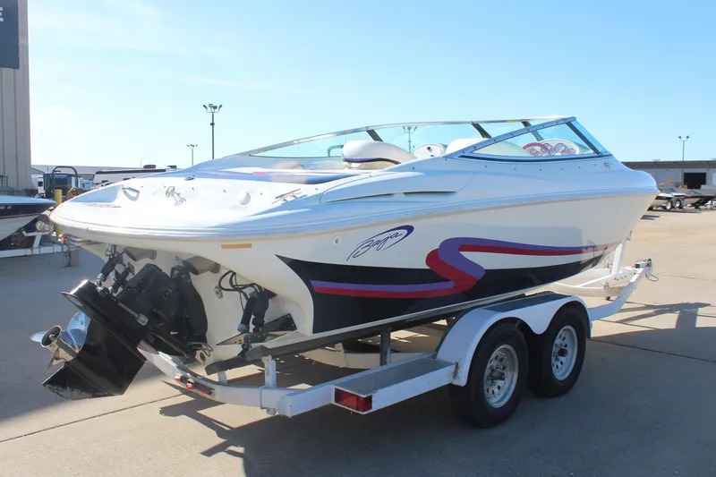Slide: The Image of 1996 Baja 232 speedboat on trailer, white with red and black accents, parked outdoors. - 8
