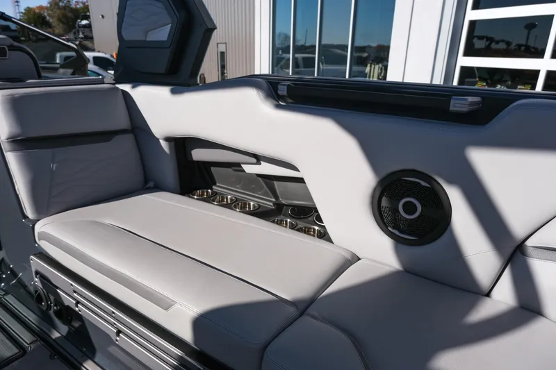 Slide: The Image of 2025 Supra SE550 boat interior with gray seating, speaker, and cup holders. - 17
