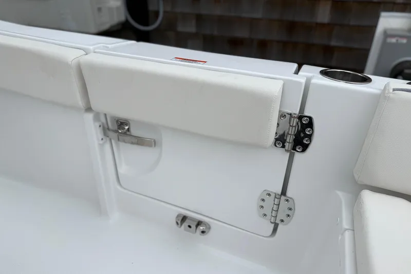 Slide: The Image of Interior view of 2026 Sea Hunt Ultra 235 SE boat, featuring white cushioned seating and stainless steel hinges. - 16