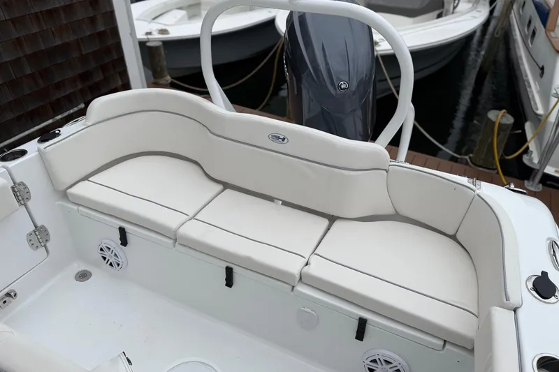 Slide: The Image of 2026 Sea Hunt Ultra 235 SE boat with white cushioned seating and motor. - 17