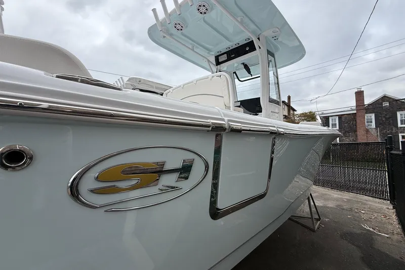 Slide: The Image of 2026 Sea Hunt Ultra 235 SE boat, sleek design, parked outdoors, overcast sky. - 19