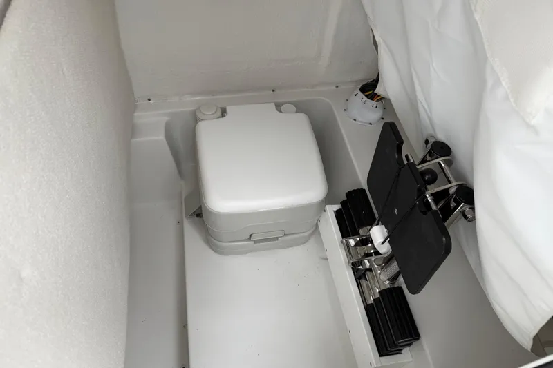 Slide: The Image of 2026 Sea Hunt Ultra 235 SE boat interior with portable toilet and foot pedal controls. - 20