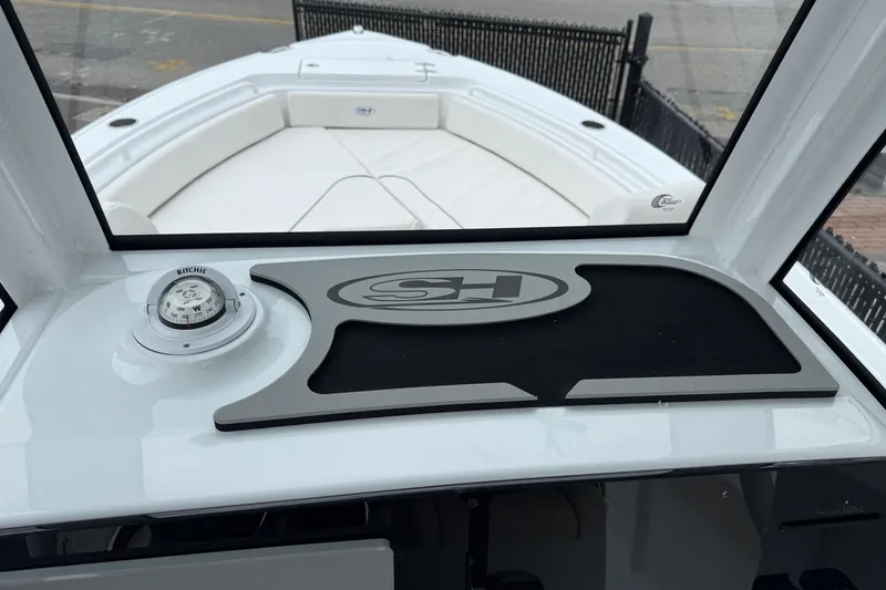 Slide: The Image of 2026 Sea Hunt Ultra 235 SE boat dashboard with compass and logo mat. - 5