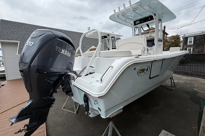 Slide: The Image of 2026 Sea Hunt Ultra 235 SE boat with Yamaha 300 engine, docked outdoors. - 6