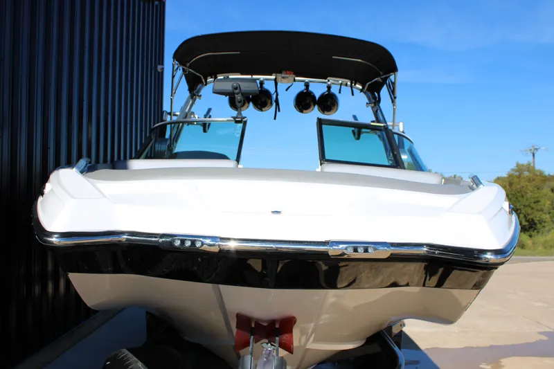 Slide: The Image of 2018 MasterCraft XT22 boat with sleek design and black canopy, docked outdoors. - 24