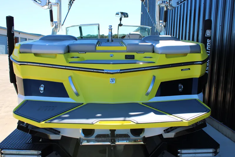 Slide: The Image of 2018 MasterCraft XT22 boat, vibrant yellow and gray, rear view in a marina setting. - 4