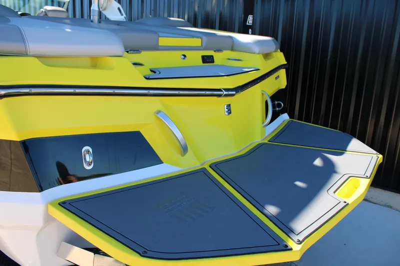Slide: The Image of 2018 MasterCraft XT22 boat with vibrant yellow and gray detailing, rear view. - 5