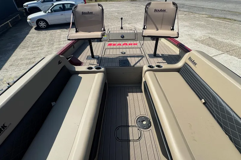 Slide: The Image of 2026 SeaArk Easy 200 boat interior with seating and cup holders, parked in a lot. - 11