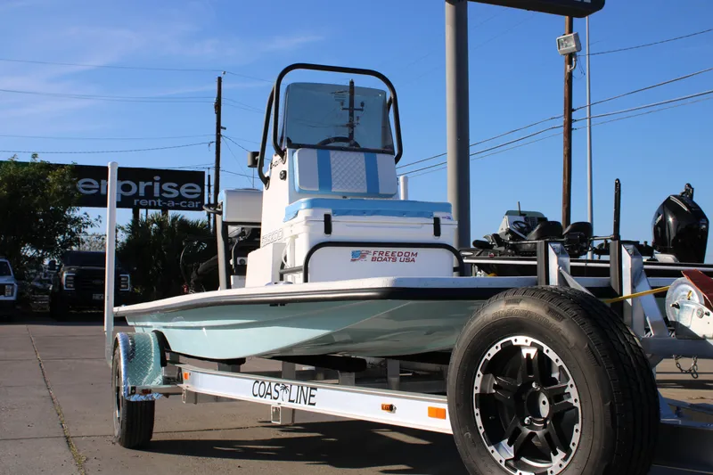 Slide: The Image of 2026 Freedom Boats Chiquita on trailer, displayed outdoors under clear blue sky. - 18