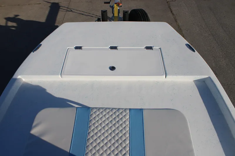 Slide: The Image of 2026 Freedom Boats Chiquita deck with blue and white seating and storage compartment. - 8