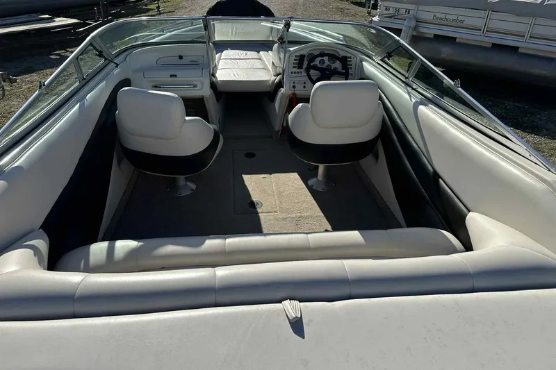 Slide: The Image of 1994 Crownline 225 BR boat interior with white seating and steering console. - 2