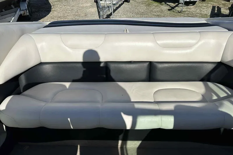 Slide: The Image of 1994 Crownline 225 BR boat interior with white and black seating, shadow visible. - 3