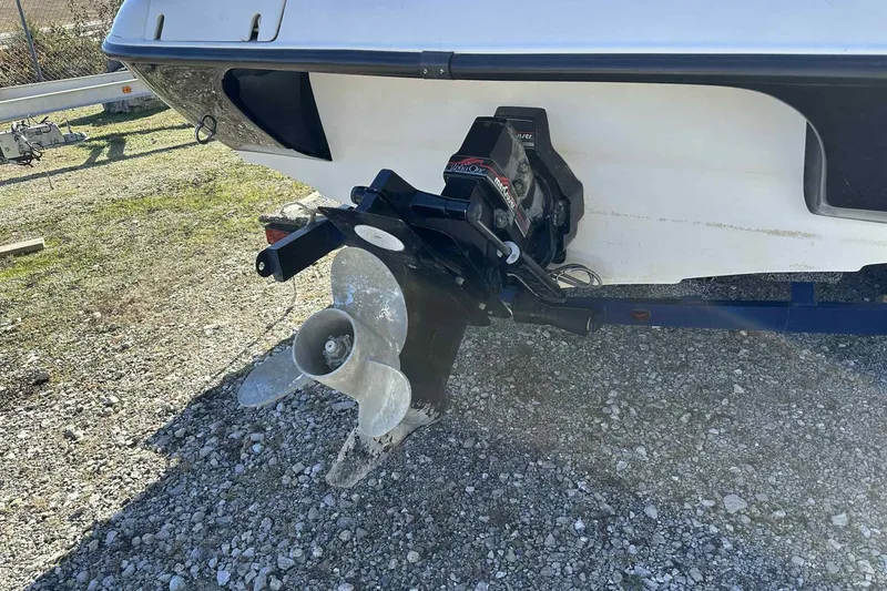 Slide: The Image of 1994 Crownline 225 BR boat stern with propeller and outdrive on gravel surface. - 5