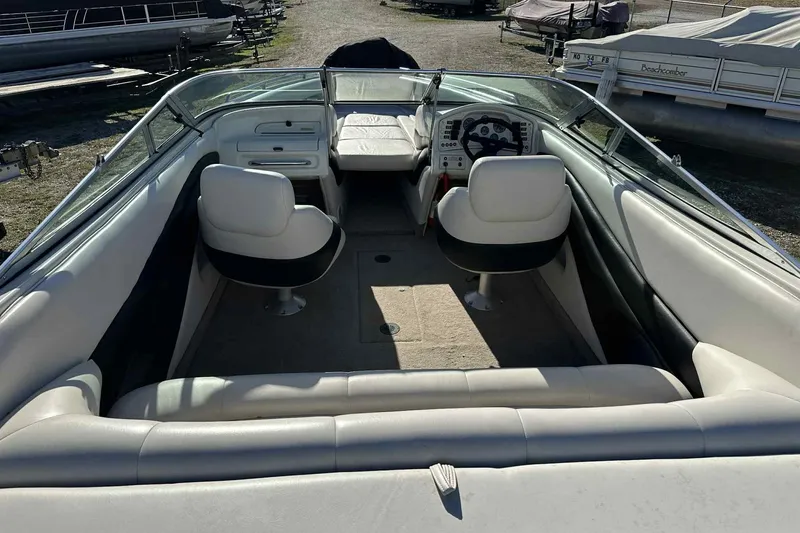 Slide: The Image of 1994 Crownline 225 BR boat interior with white seating and steering console. - 7