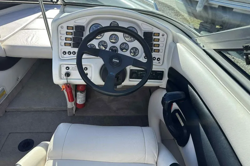 Slide: The Image of 1994 Crownline 225 BR boat dashboard with steering wheel and control panel. - 8