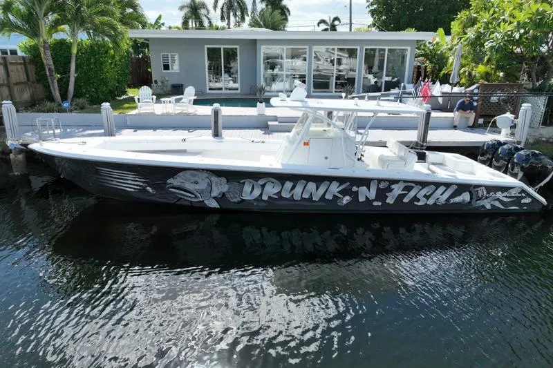 The Image of 2010 SeaHunter 40 boat named "Drunk-N-Fish" docked by a waterfront house. - 0