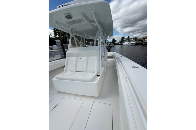 Slide: The Image of 2010 SeaHunter 40 boat with white seating, docked by a calm waterfront. - 18