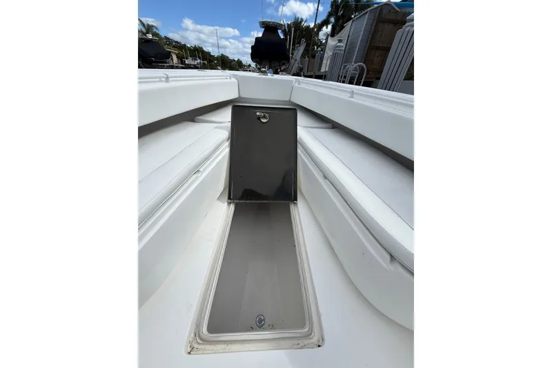 Slide: The Image of 2010 SeaHunter 40 boat interior with open storage compartment, white seating, and clear sky. - 20