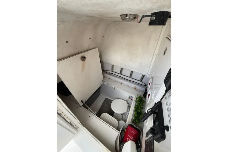 Slide: The Image of Interior of 2010 SeaHunter 40 boat showing compact bathroom with toilet and storage. - 24