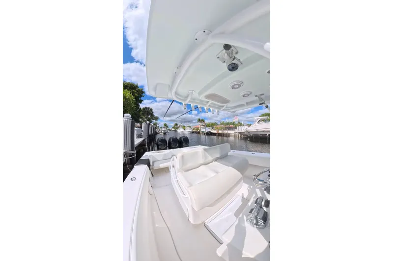 Slide: The Image of 2010 SeaHunter 40 boat interior with seating, docked by a scenic waterfront. - 7