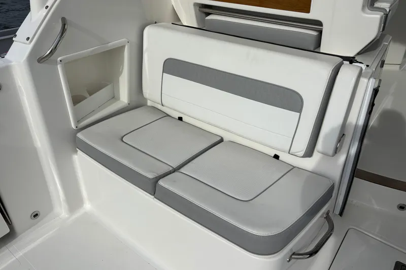 Slide: The Image of 2022 Pursuit DC 365 Dual Console boat seating area with white and gray cushions. - 14
