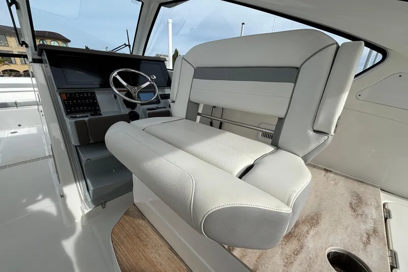 Slide: The Image of 2022 Pursuit DC 365 Dual Console boat interior with steering wheel and seating. - 19