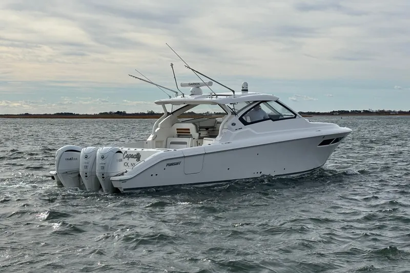 Slide: The Image of 2022 Pursuit DC 365 Dual Console boat cruising on open water. - 2