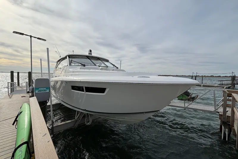 Slide: The Image of 2022 Pursuit DC 365 Dual Console boat docked on a sunny day. - 4