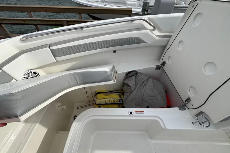 Slide: The Image of 2022 Pursuit DC 365 Dual Console boat storage compartment with life jackets and gear. - 40