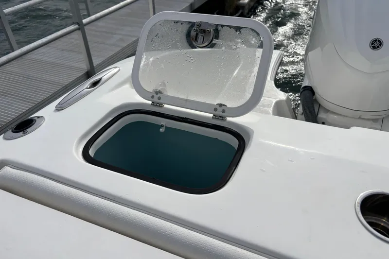 Slide: The Image of 2022 Pursuit DC 365 Dual Console boat with open storage compartment near the dock. - 8
