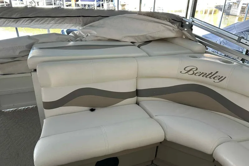 Slide: The Image of 2011 Bentley Pontoons 240/243 Cruise interior with beige seating and logo. - 8