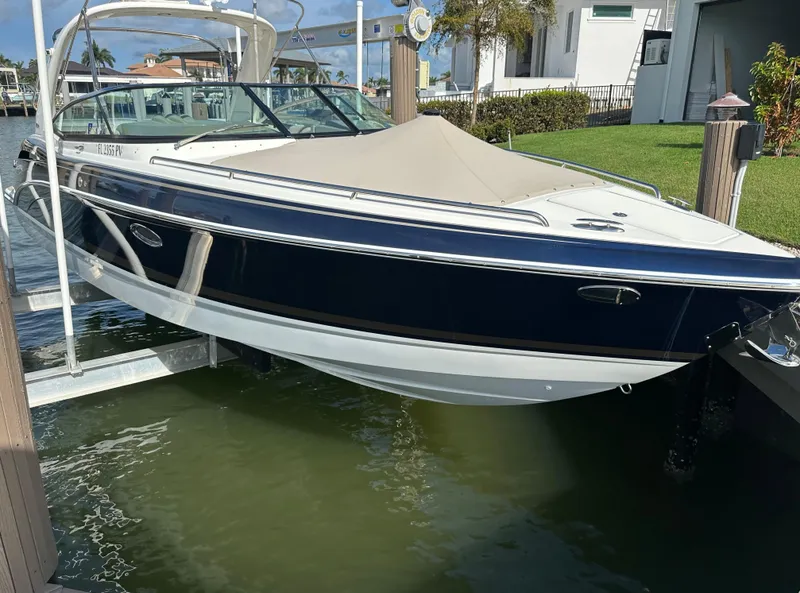 Slide: The Image of 2015 Formula 310 Bowrider boat docked on a lift by waterfront home. - 25