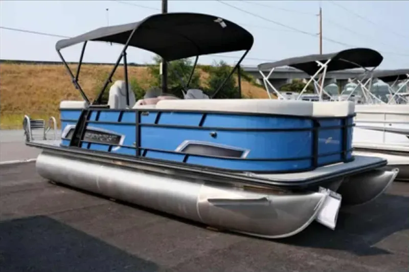 The Image of 2023 Starcraft EXS 3 pontoon boat with blue exterior and canopy, parked on asphalt. - 1