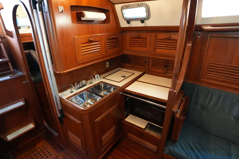 Slide: The Image of 1985 Ta Chiao 38 yacht interior with wooden cabinetry and compact kitchen area. - 19